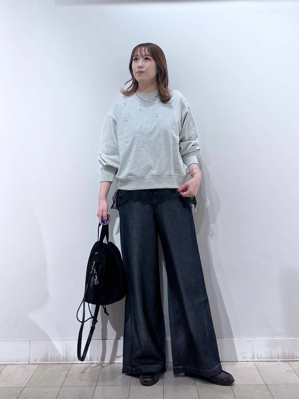 ブラック系のハンドバッグ、グレー系のTシャツ/カットソー、ブラウン系のローファーを着用したレディースの秋コーディネートの1枚目の写真