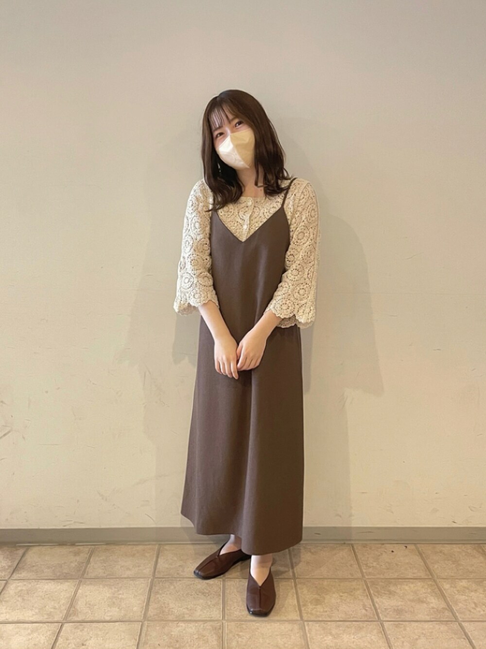 ベージュ系のトップス、ブラウン系のワンピース、ブラウン系のパンプスを着用したレディースの秋コーディネートの1枚目の写真