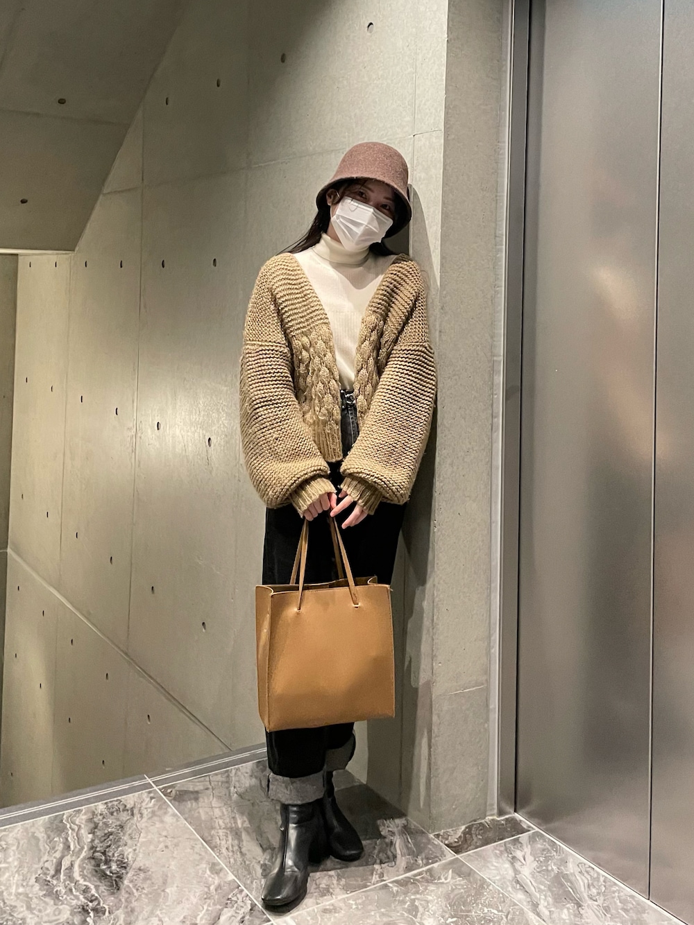 ホワイト系のニット/セーター、ベージュ系のカーディガン/ボレロ、ブラック系のデニムパンツを着用したレディースの秋コーディネートの1枚目の写真