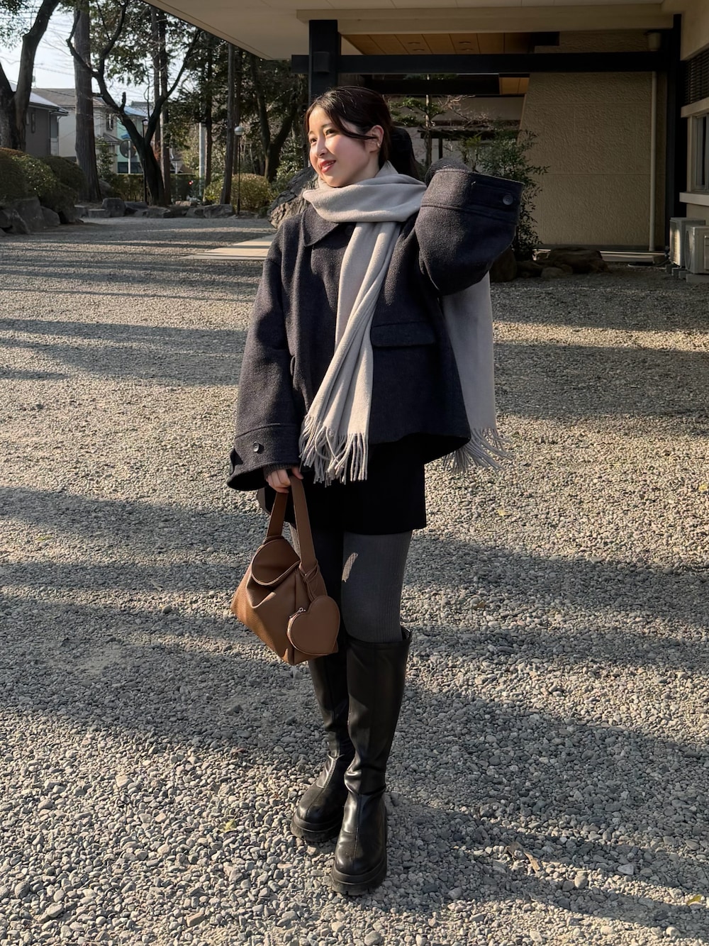 ブラック系のその他パンツ、グレー系のニット/セーター、イエロー系のハンドバッグを着用したレディースの冬コーディネートの1枚目の写真