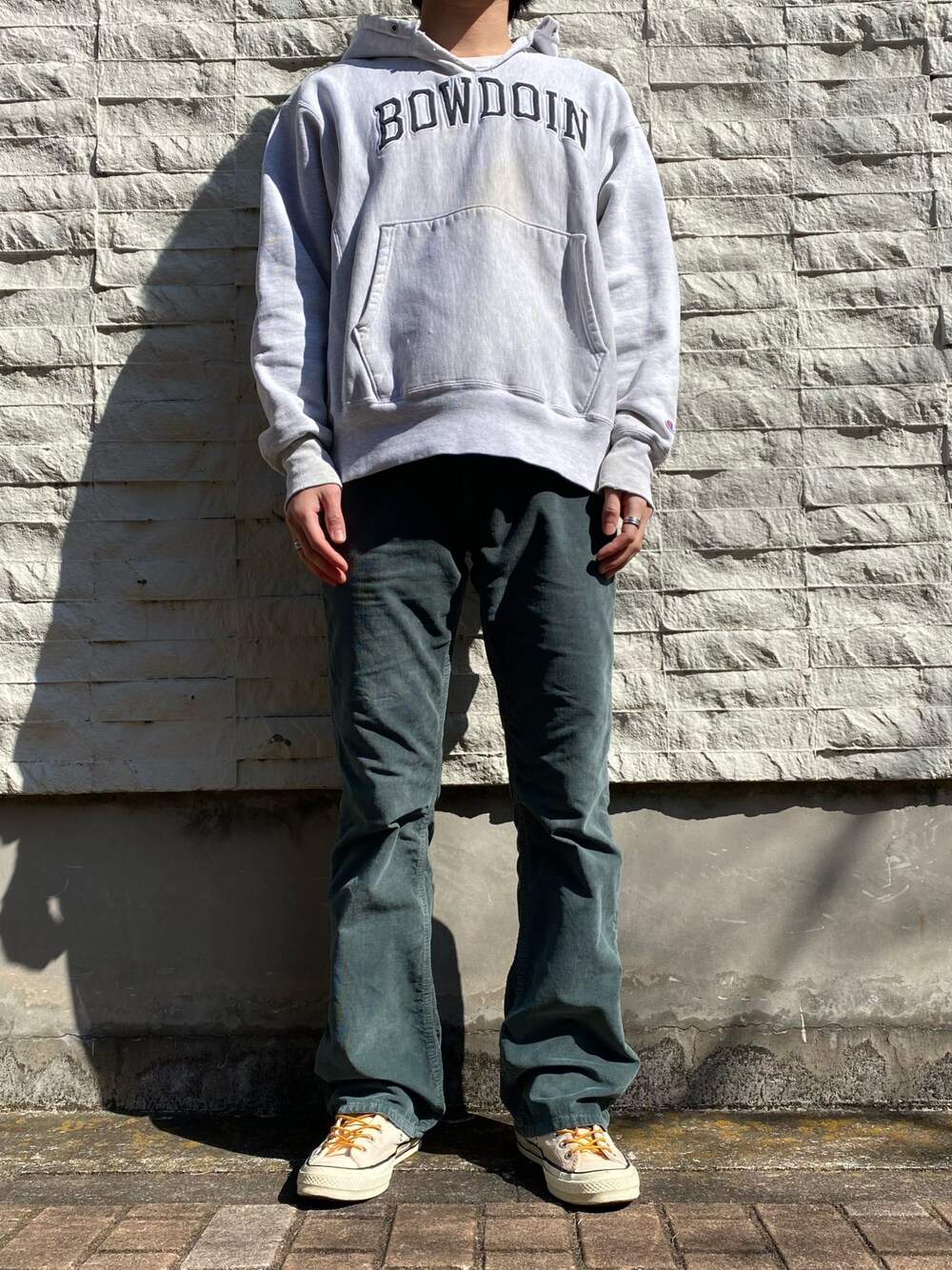 グレー系のパーカー、グリーン系のその他パンツ、イエロー系のスニーカーを着用したメンズの春コーディネートの1枚目の写真