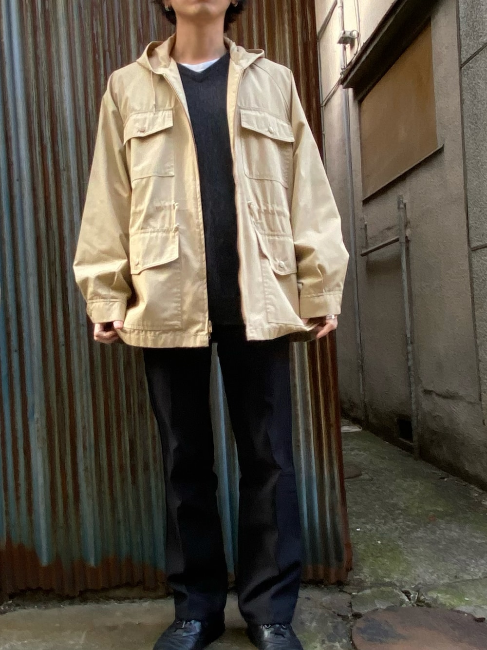 ブラック系のスラックス、ブラック系のスニーカー、ブラック系のニット/セーターを着用したメンズの冬コーディネートの1枚目の写真