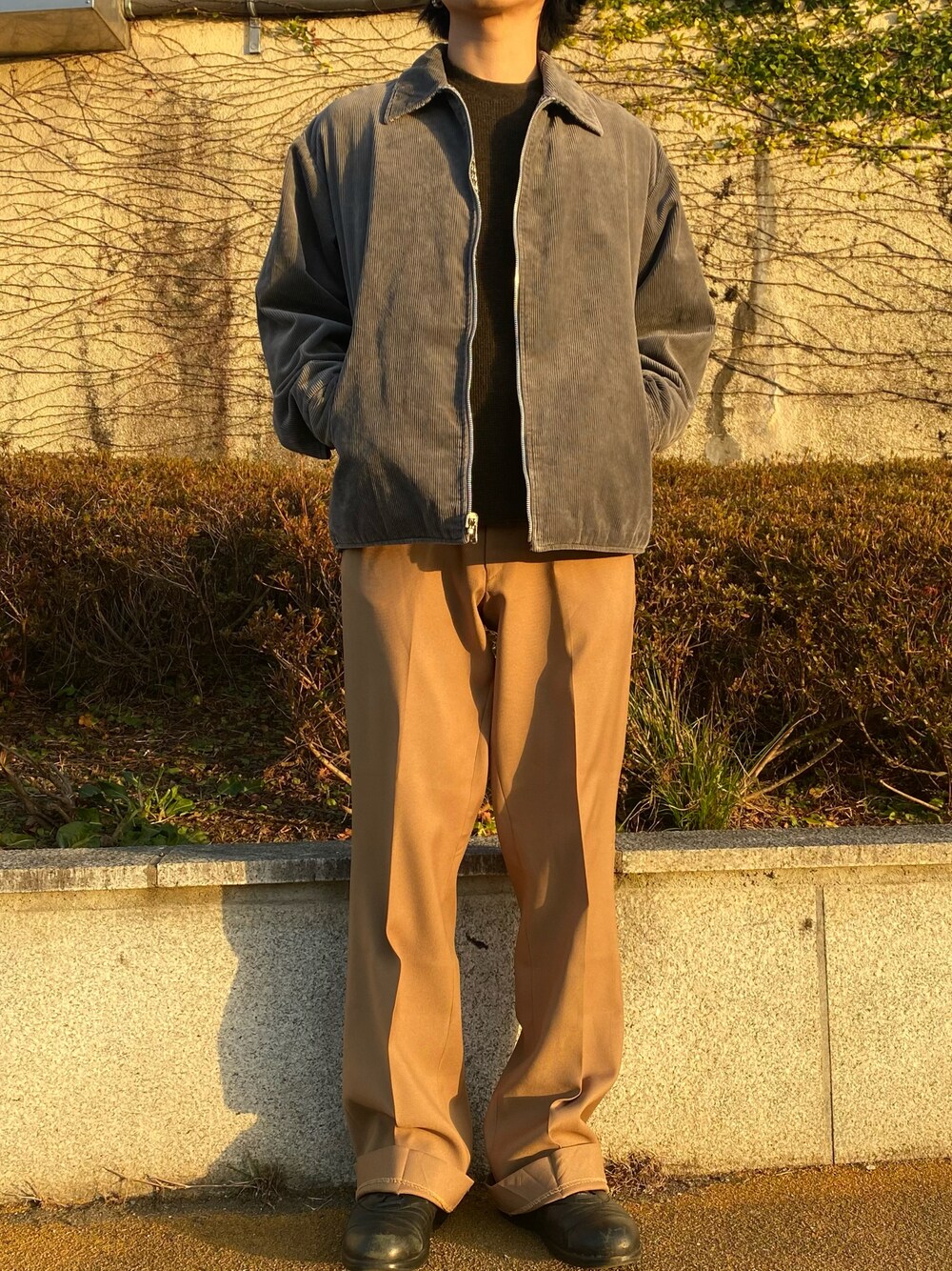 グレー系のジャケット/アウター、ブラウン系のパンツ、ブラック系のスニーカーを着用したメンズの冬コーディネートの1枚目の写真