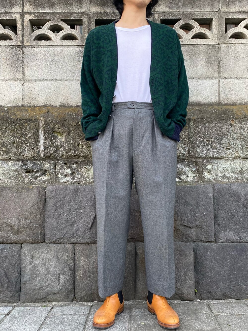 グリーン系のカーディガン/ボレロ、グレー系のスラックス、ブラウン系のシューズを着用したメンズの春コーディネートの1枚目の写真