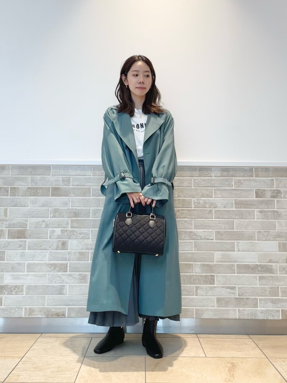 「テチチ(Te chichi)、トレンチコート、グリーン、Tシャツ、スカート、ブラック、通勤コーデ、秋コーデ」｜「Te chichiのキルティングボストンバック（ハンドバッグ、ブラック系）」を使った、m   aさん（レディース・162cm）の秋コーディネートの1枚目の写真