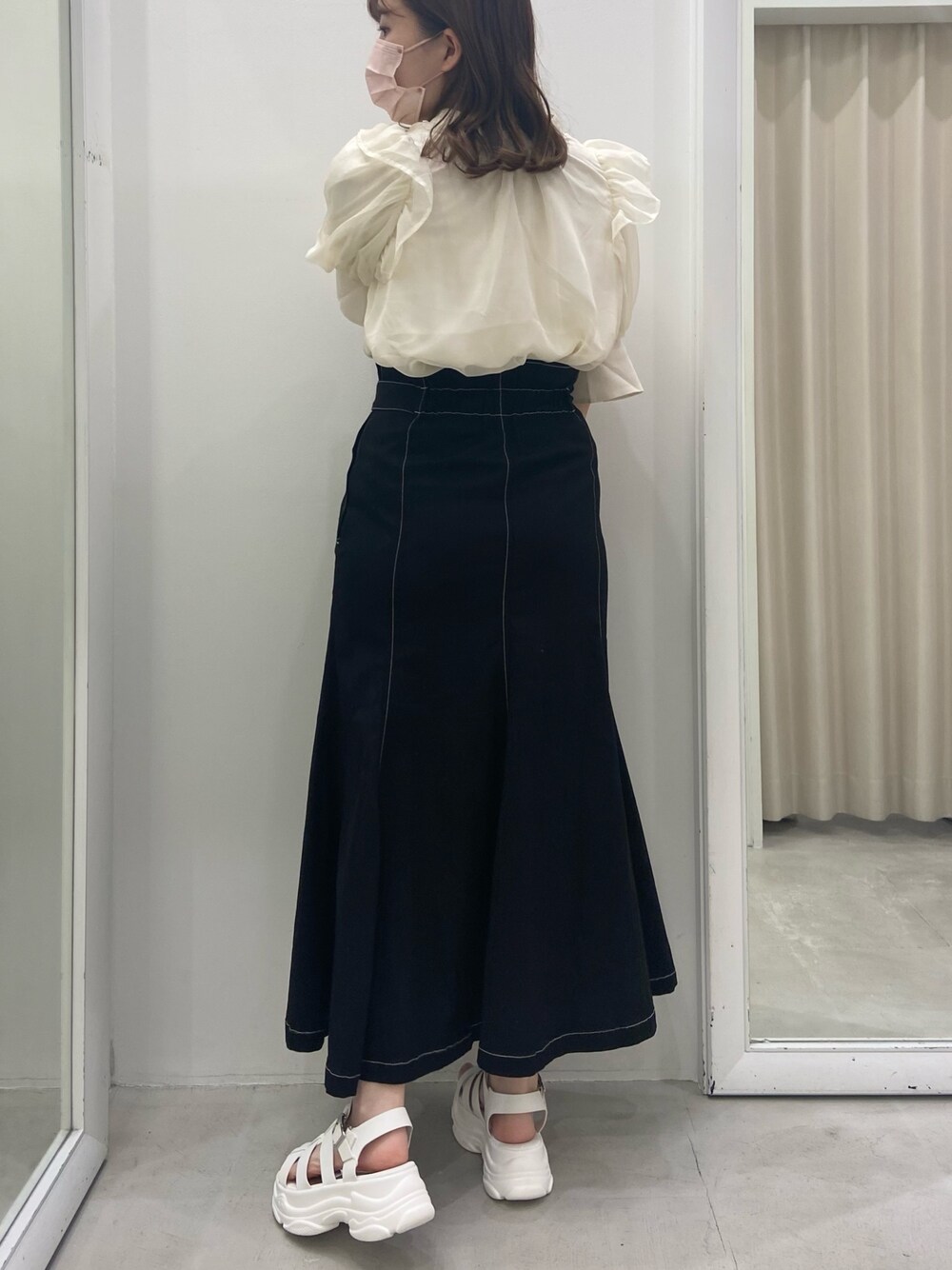 ホワイト系のシャツ/ブラウス、ブラック系のスカート、ホワイト系のサンダルを着用したレディースの夏コーディネートの2枚目の写真