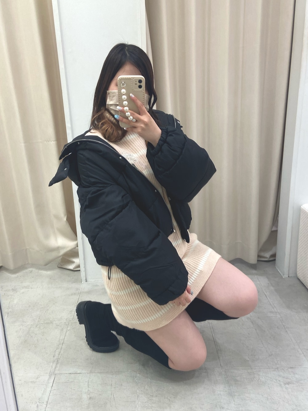 ブラック系のブーツ、ピンク系のニット/セーター、ブラック系のダウンジャケット/コートを着用したレディースの冬コーディネートの1枚目の写真