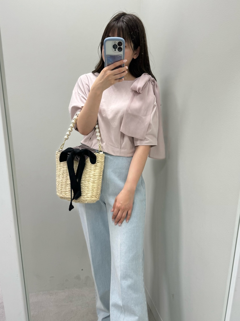 ピンク系のTシャツ/カットソー、ブラック系のかごバッグ、ブルー系のデニムパンツを着用したレディースの春コーディネートの1枚目の写真