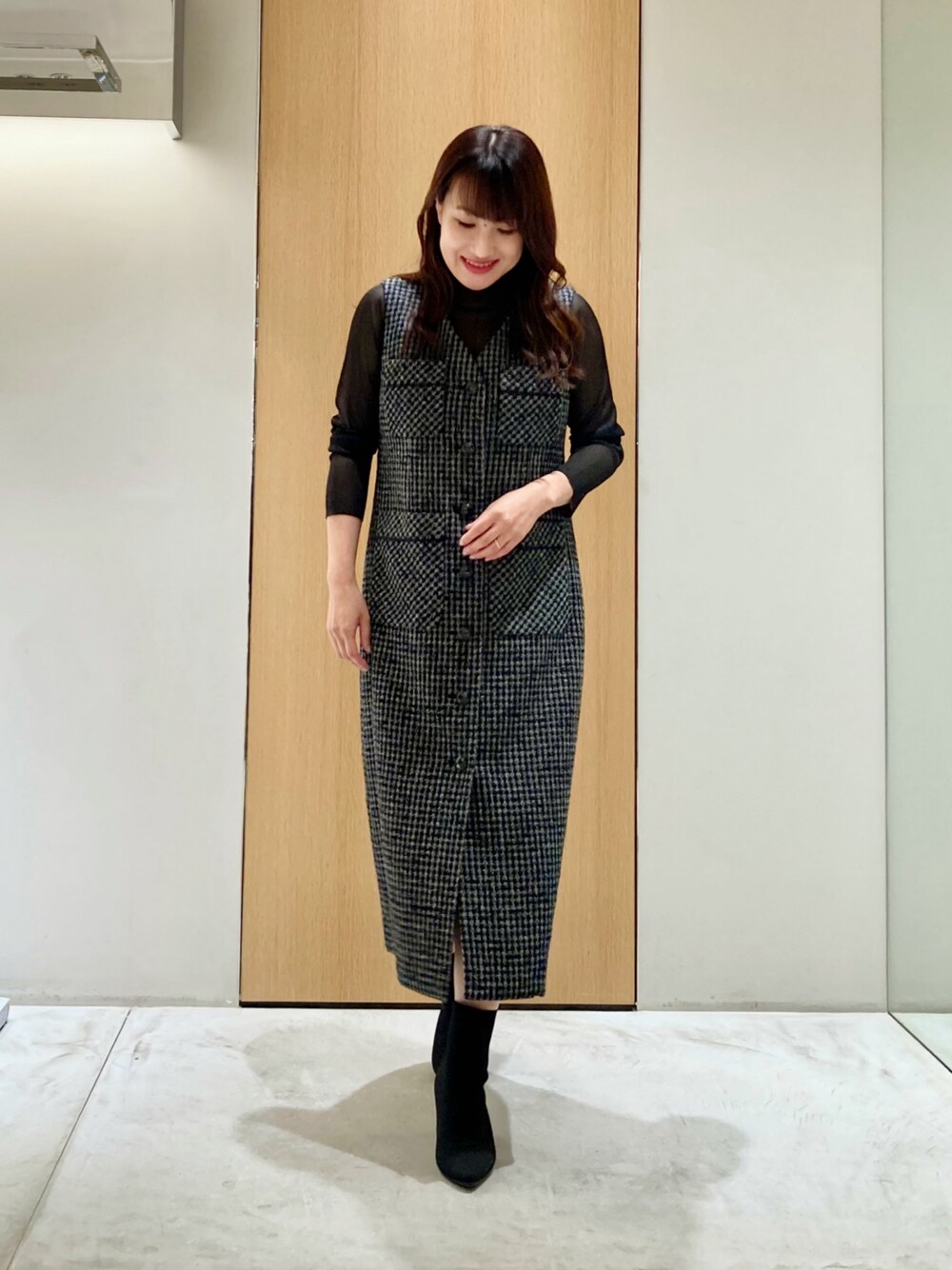 ブラック系のニット/セーター、ブラック系のワンピースを着用したレディースの秋コーディネートの1枚目の写真