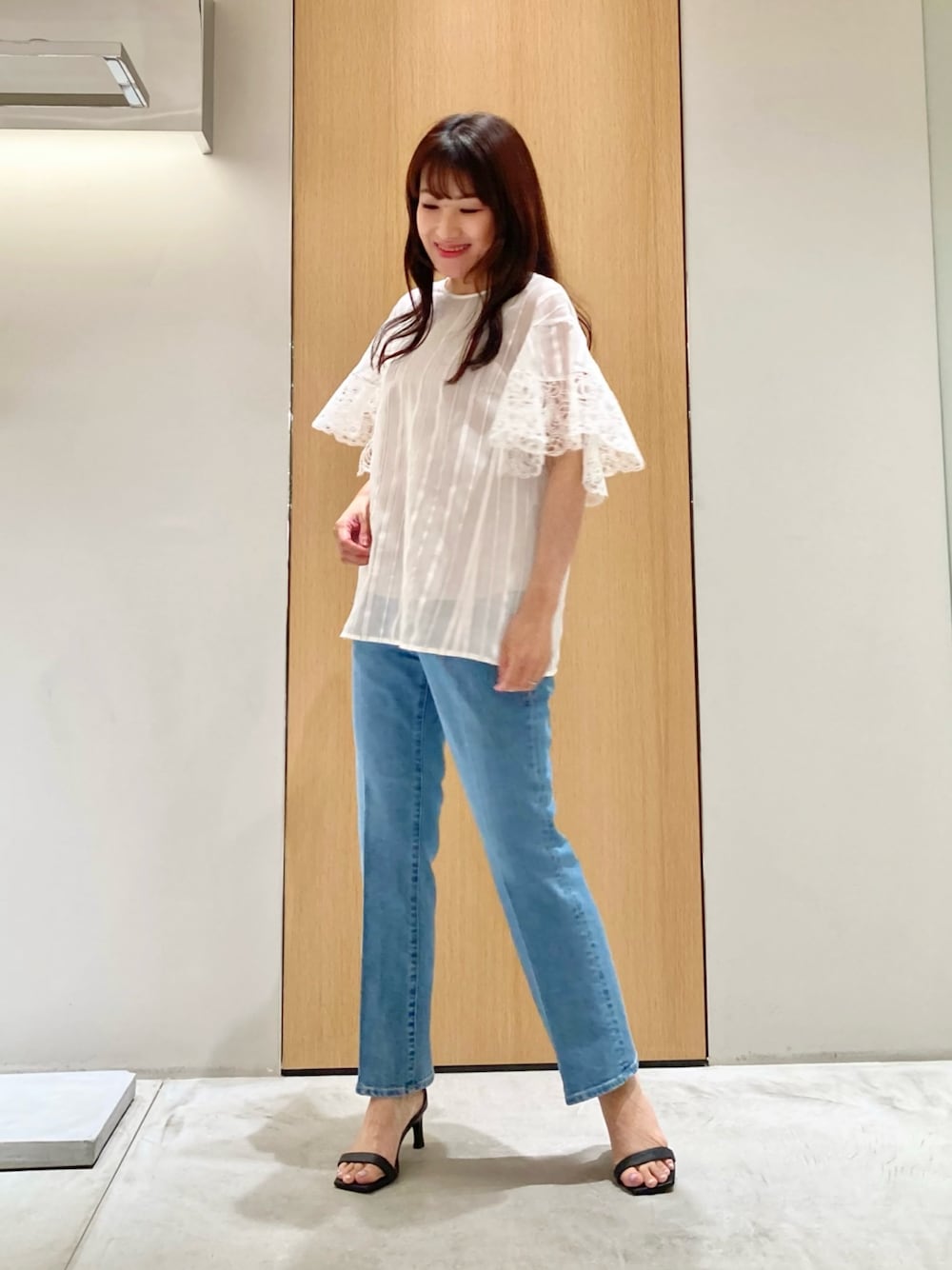 ホワイト系のシャツ/ブラウス、ブルー系のデニムパンツ、ゴールド系のイヤリングを着用したレディースの夏コーディネートの1枚目の写真