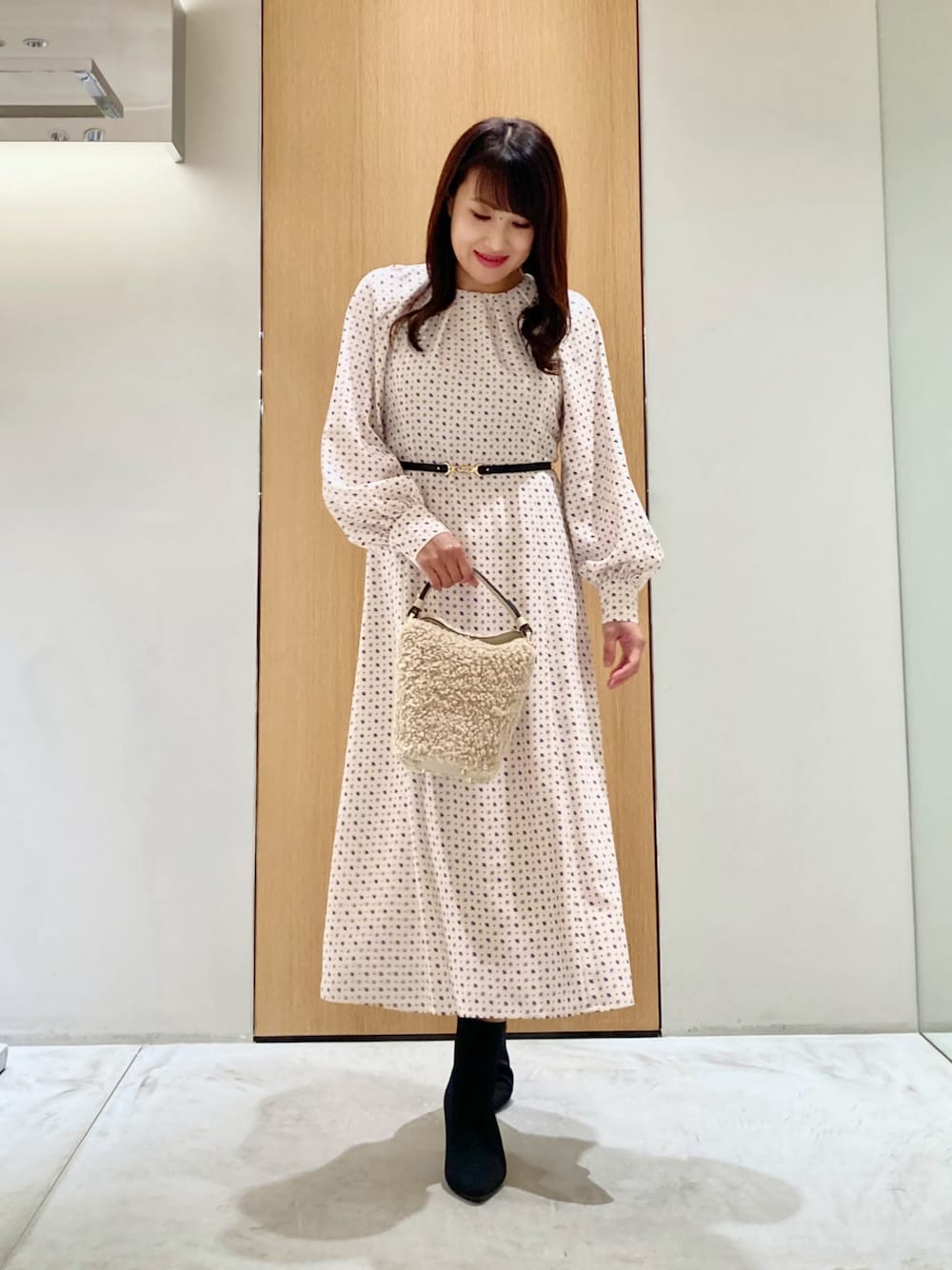 ベージュ系のワンピース、ホワイト系のハンドバッグを着用したレディースの秋コーディネートの1枚目の写真