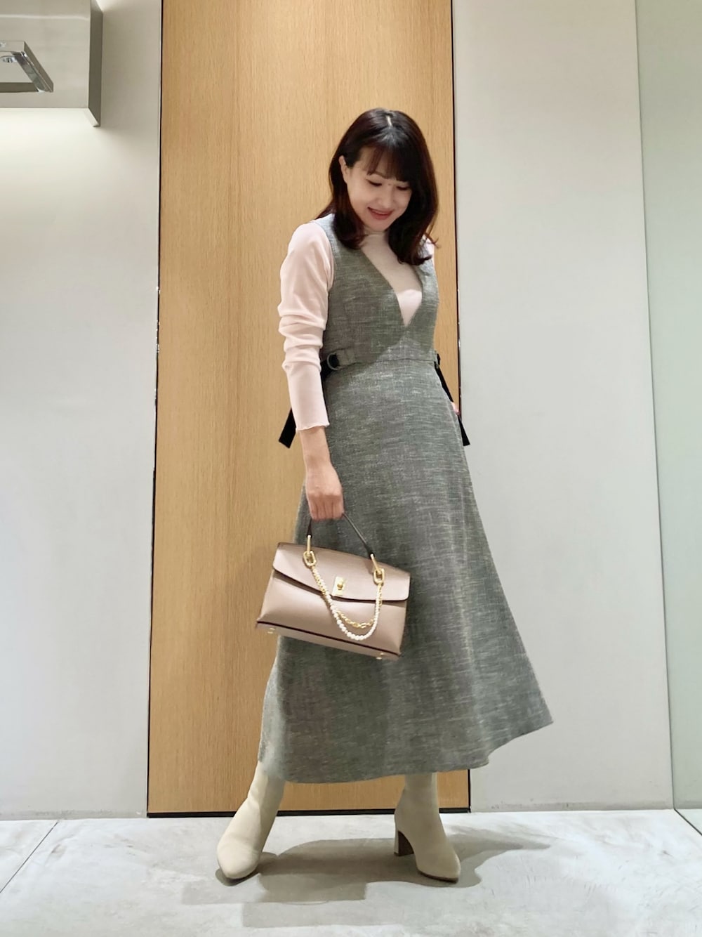 グレー系のワンピース、ピンク系のTシャツ/カットソー、ピンク系のハンドバッグを着用したレディースの秋コーディネートの1枚目の写真