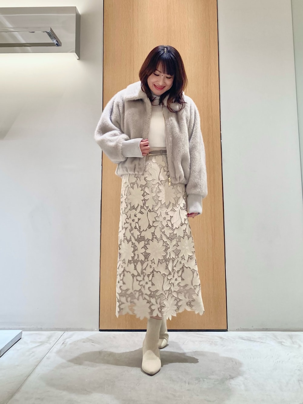 ベージュ系のブルゾン、ホワイト系のニット/セーター、ベージュ系のスカートを着用したレディースの秋コーディネートの1枚目の写真