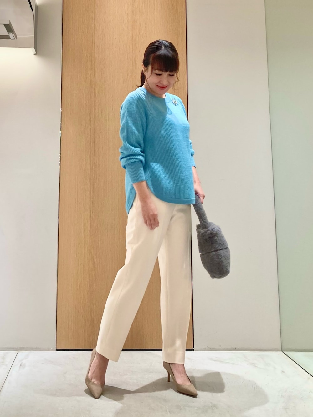 ブルー系のニット/セーター、グレー系のハンドバッグ、ホワイト系のその他パンツを着用したレディースの秋コーディネートの1枚目の写真