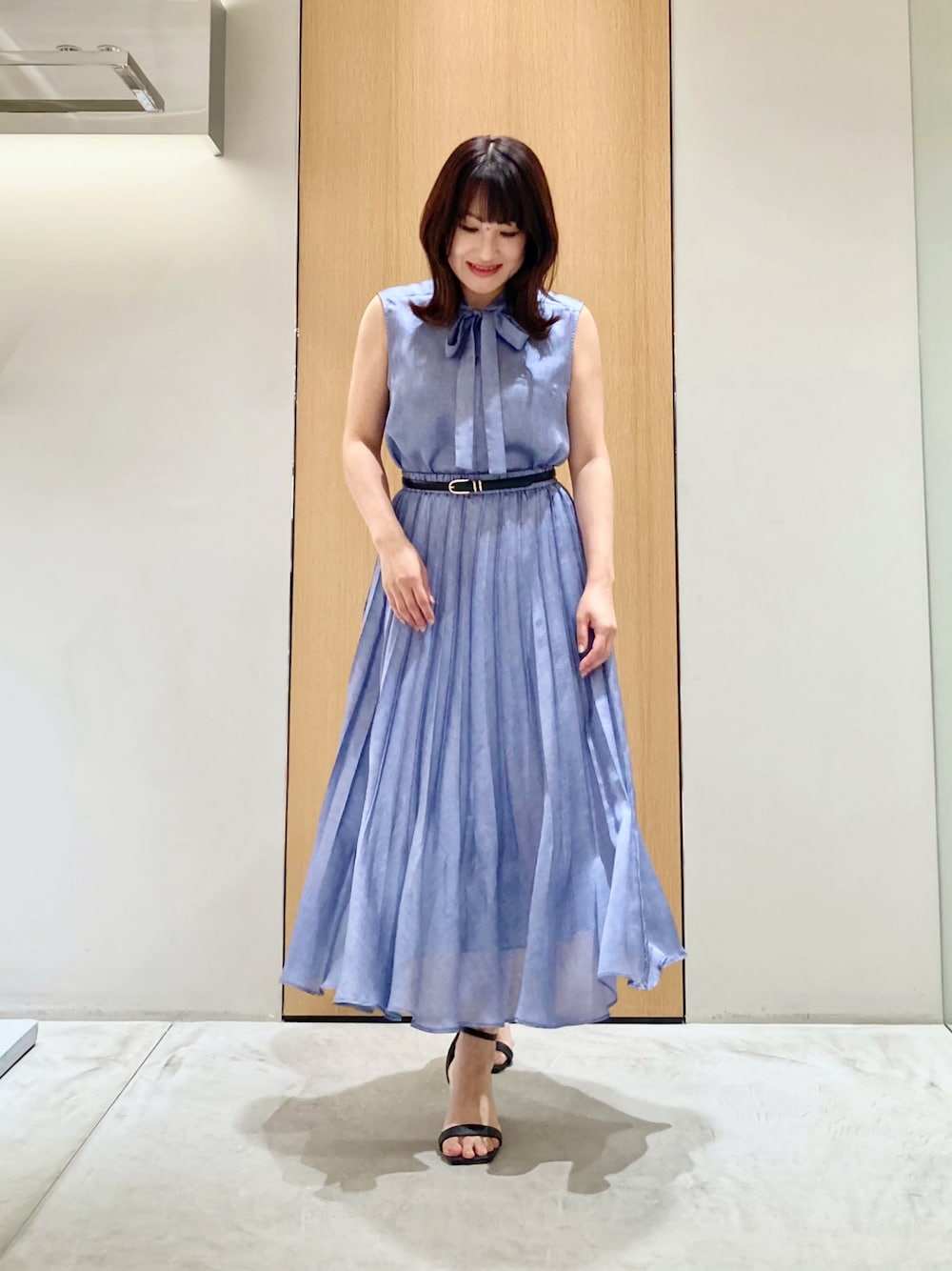 ブルー系のシャツ/ブラウス、ブルー系のスカート、ブラック系のベルトを着用したレディースの夏コーディネートの1枚目の写真