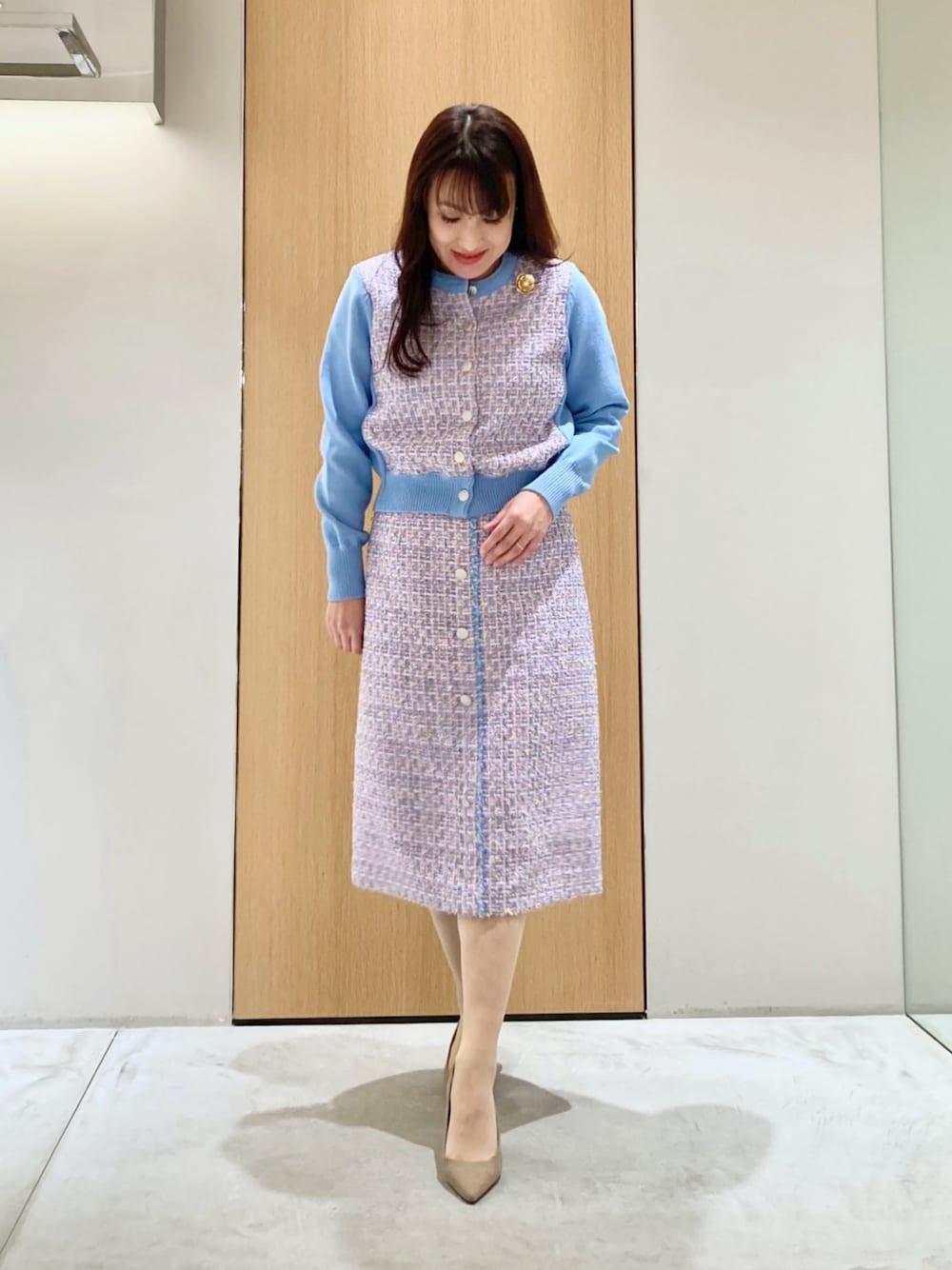 ブルー系のカーディガン/ボレロ、ブルー系のスカート、ゴールド系のイヤリングを着用したレディースの春コーディネートの1枚目の写真