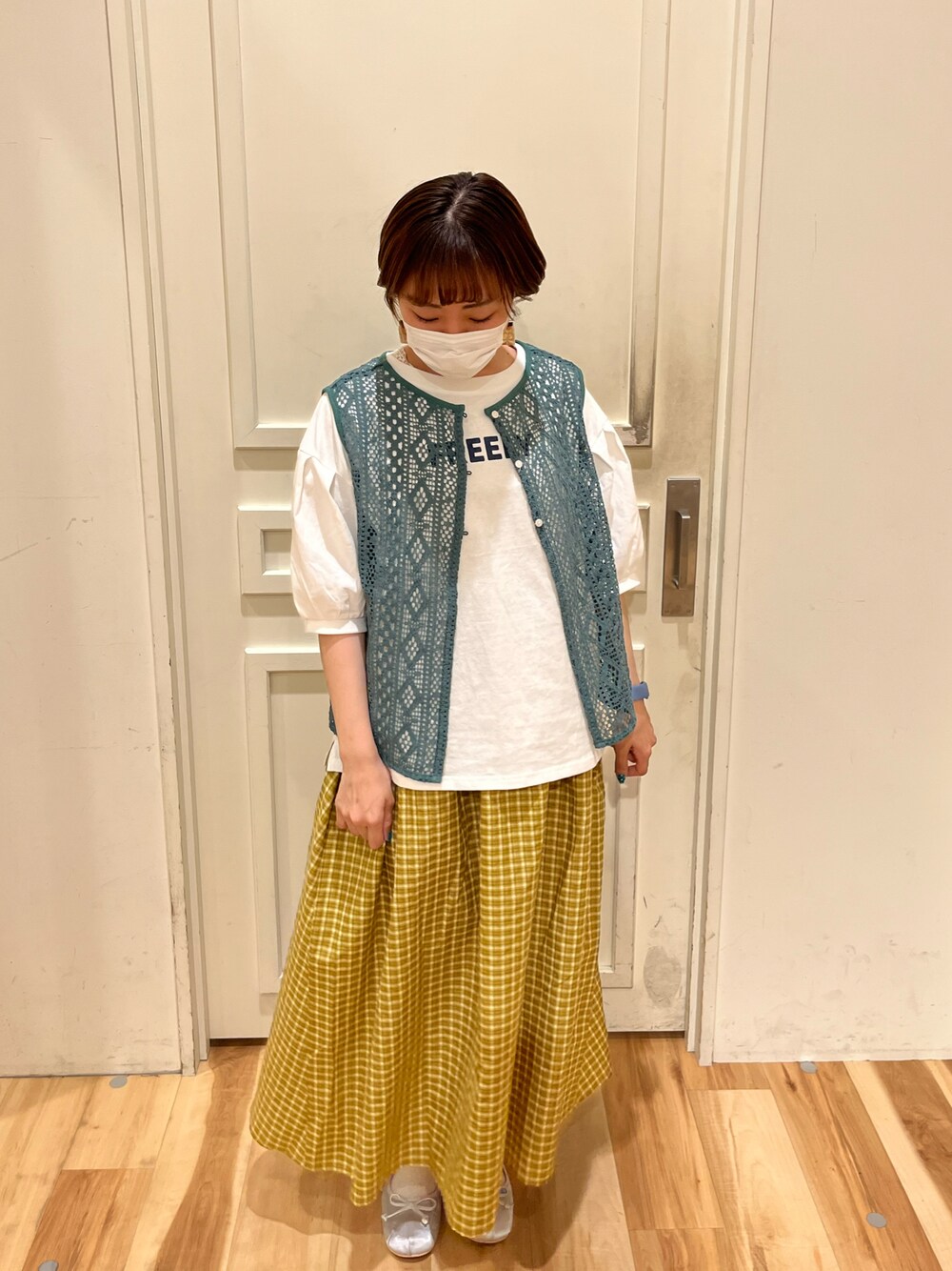 グリーン系のTシャツ/カットソー、イエロー系のワンピース、シルバー系のバレエシューズを着用したレディースの春コーディネートの1枚目の写真