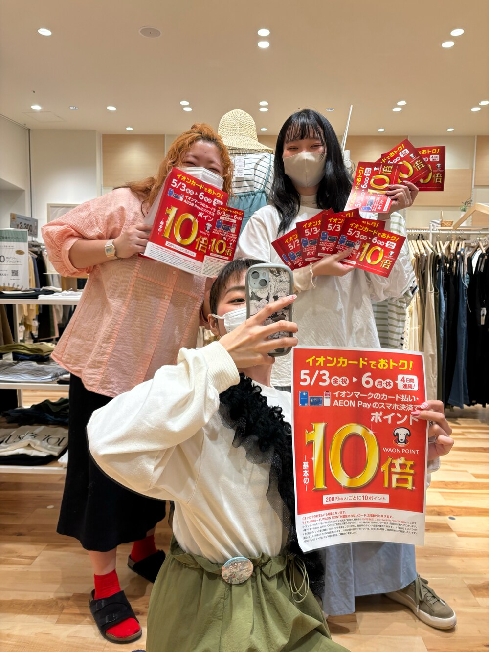 オレンジ系のシャツ/ブラウス、グリーン系のワンピース、ホワイト系のTシャツ/カットソーを着用したレディースの春コーディネートの1枚目の写真