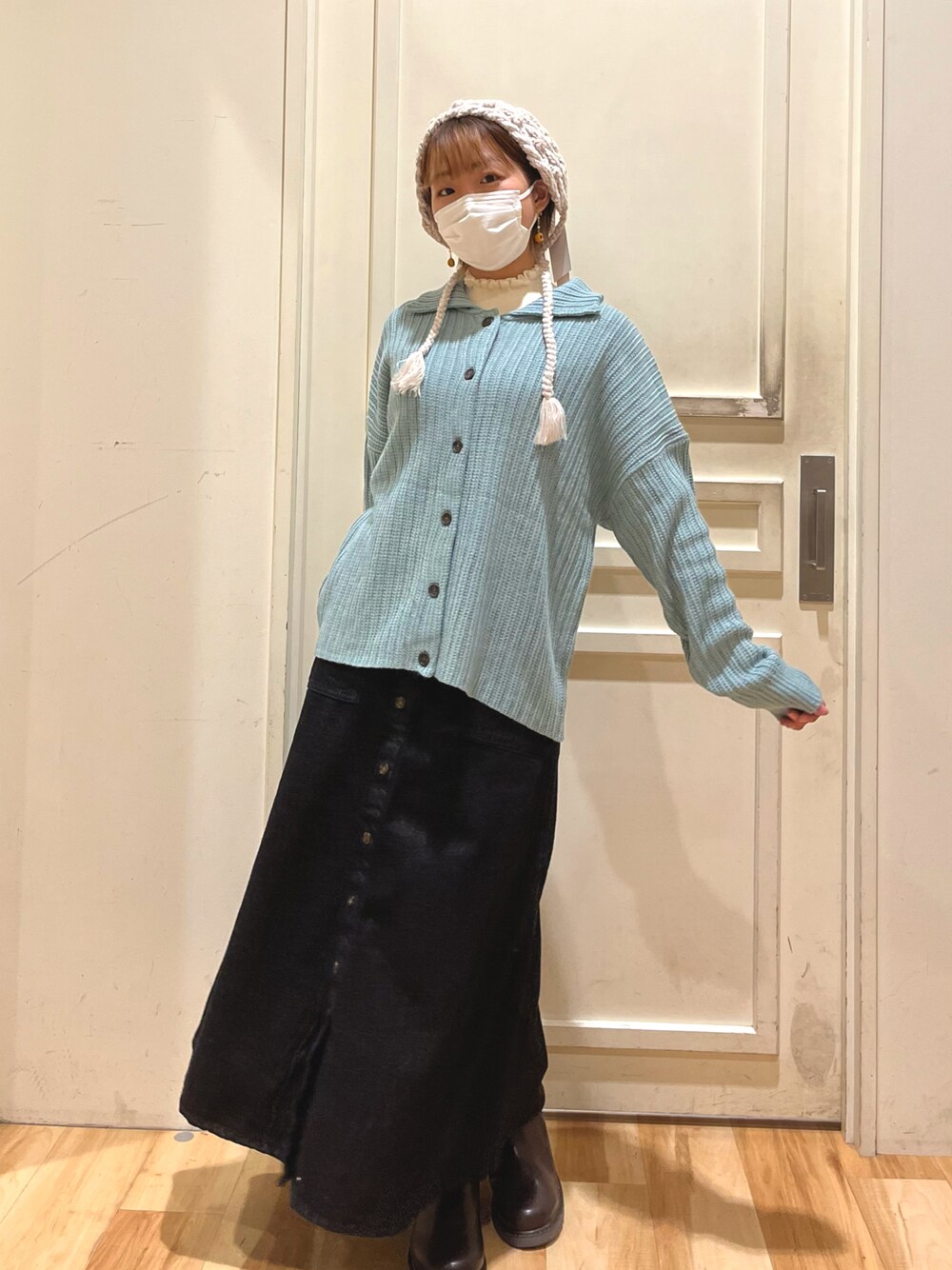 ホワイト系のニット/セーター、ブルー系のカーディガン/ボレロ、ブラック系のデニムスカートを着用したレディースの秋コーディネートの1枚目の写真