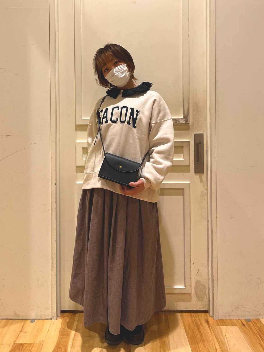 ホワイト系のTシャツ/カットソー、ブラック系のシャツ/ブラウス、ブラック系のショルダーバッグを着用したレディースの冬コーディネートの1枚目の写真