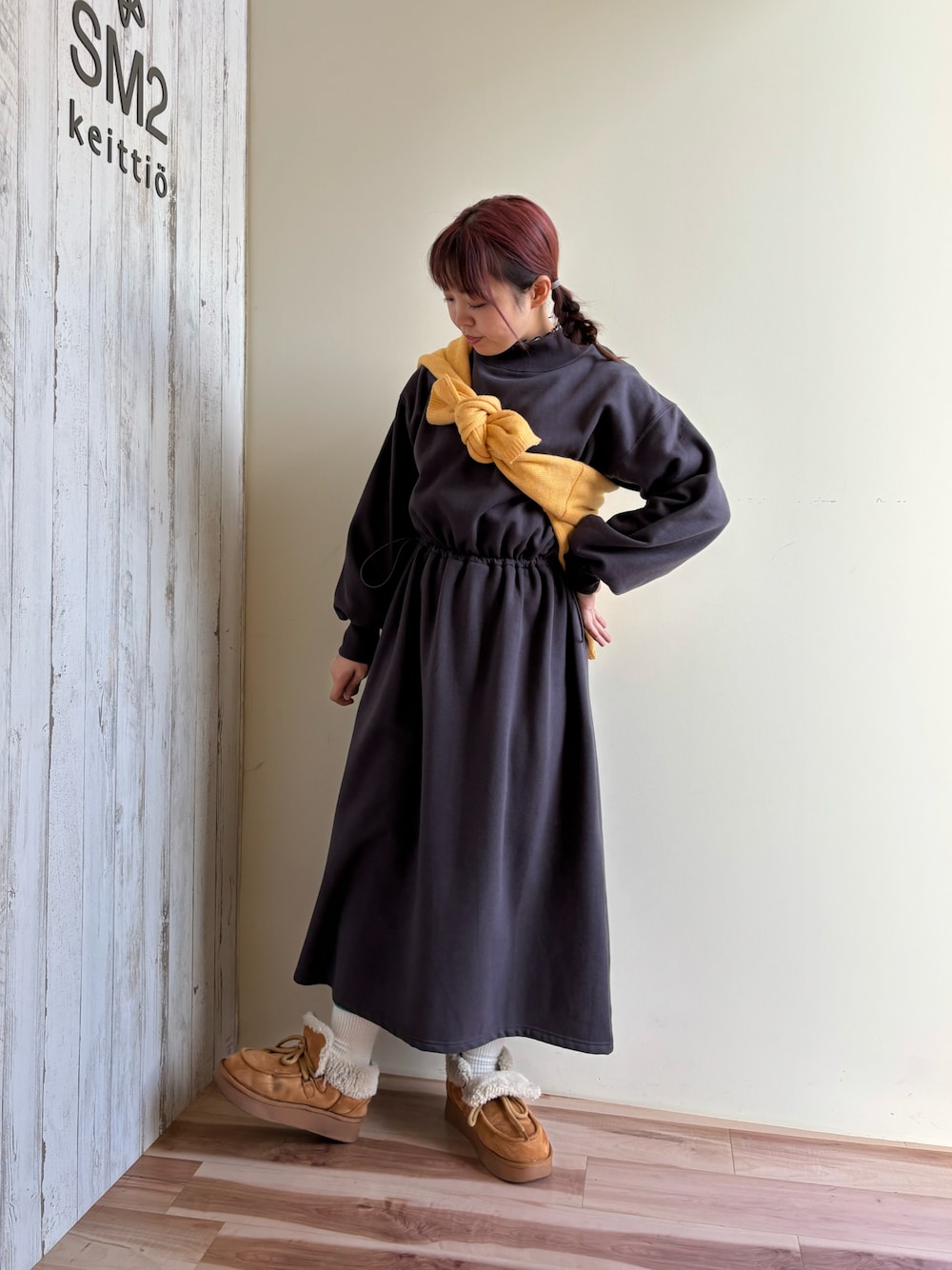 グレー系のワンピース、ブラウン系のカーディガン/ボレロを着用したレディースの冬コーディネートの1枚目の写真