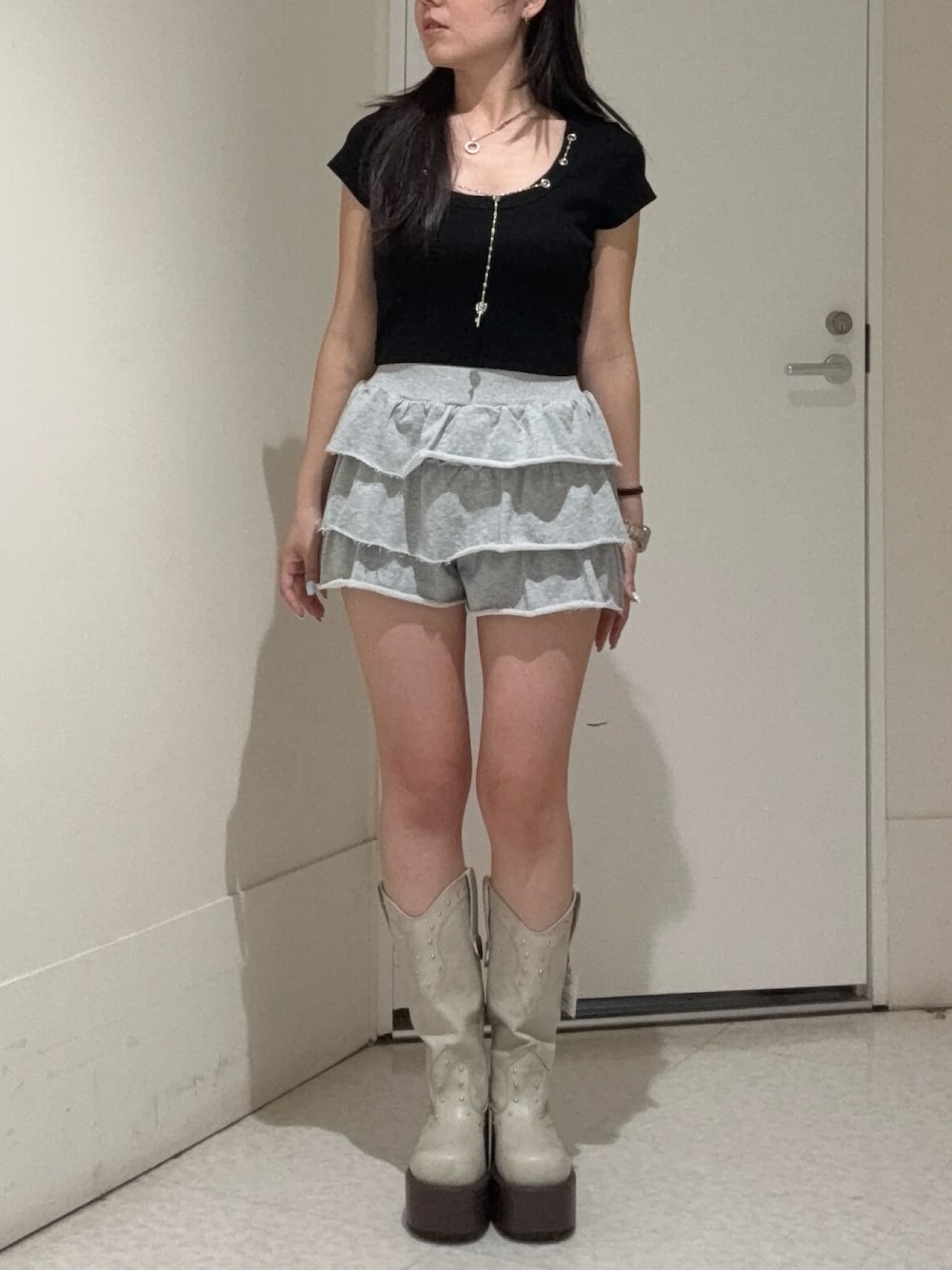 ブラック系のTシャツ/カットソー、グレー系のその他パンツ、ホワイト系のブーツを着用したレディースの春コーディネートの1枚目の写真