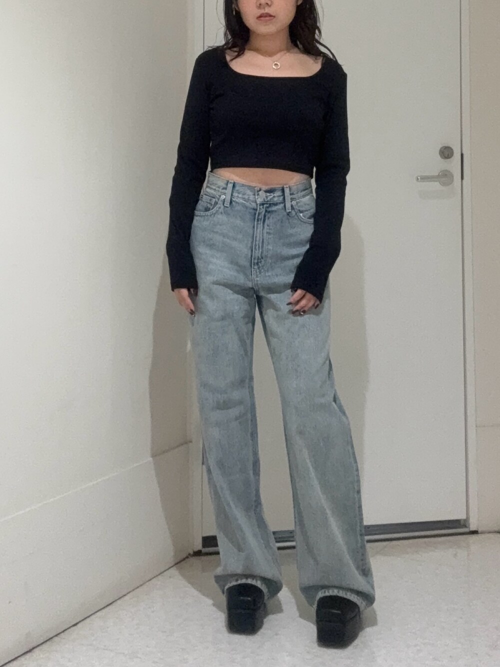 ブラック系のブーツ、ブルー系のデニムパンツ、ブラック系のTシャツ/カットソーを着用したレディースの秋コーディネートの1枚目の写真