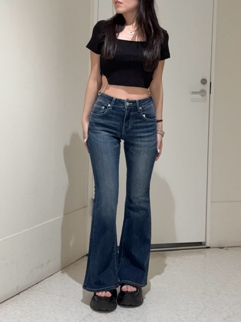 ブラック系のTシャツ/カットソー、ブルー系のデニムパンツ、ブラック系のサンダルを着用したレディースの春コーディネートの1枚目の写真