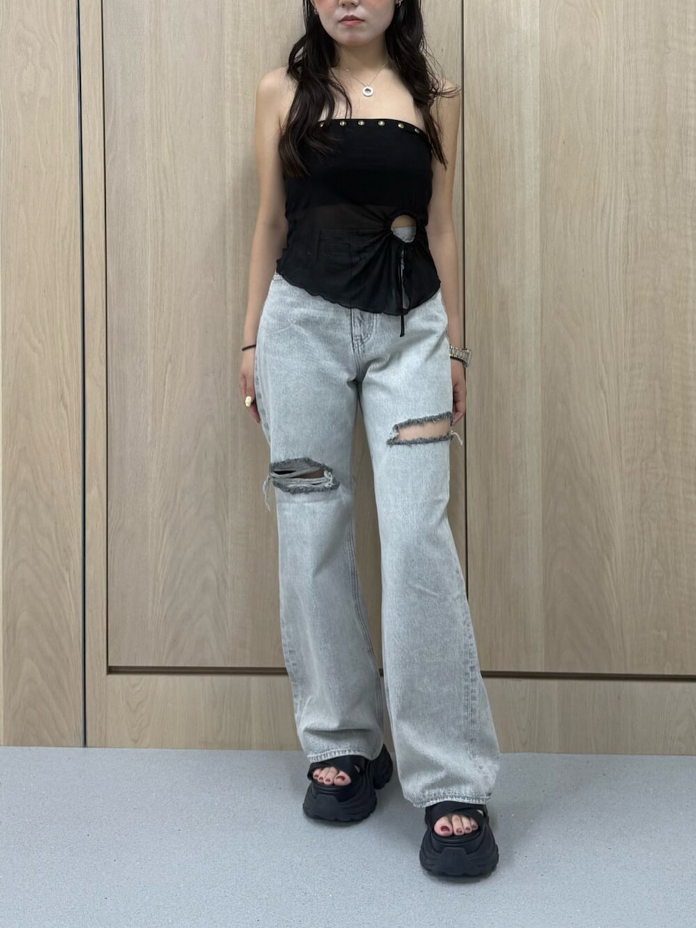 グレー系のデニムパンツ、ブラック系のサンダル、ブラック系のキャミソールを着用したレディースの夏コーディネートの1枚目の写真
