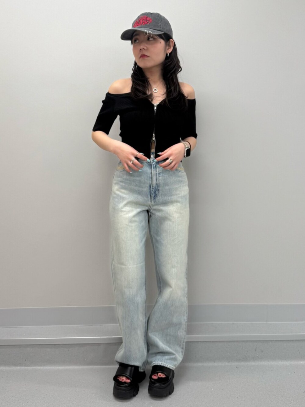 ブラウン系のサンダル、ブラック系のTシャツ/カットソー、ブルー系のデニムパンツを着用したレディースの春コーディネートの1枚目の写真