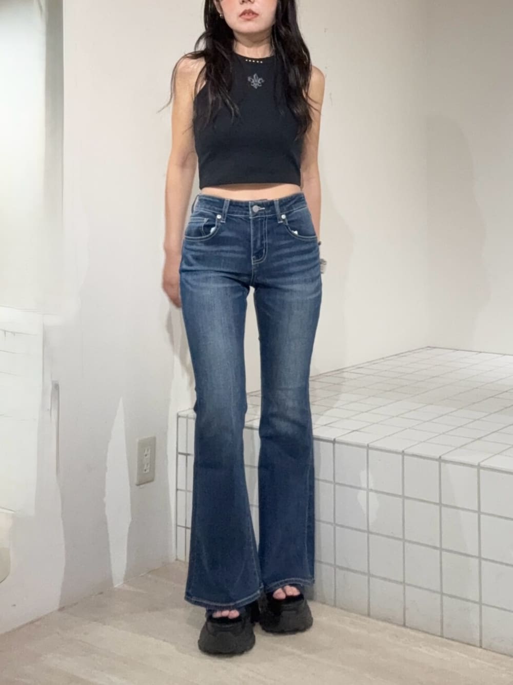 ブラック系のサンダル、ブルー系のデニムパンツ、ブラック系のタンクトップを着用したレディースの夏コーディネートの1枚目の写真