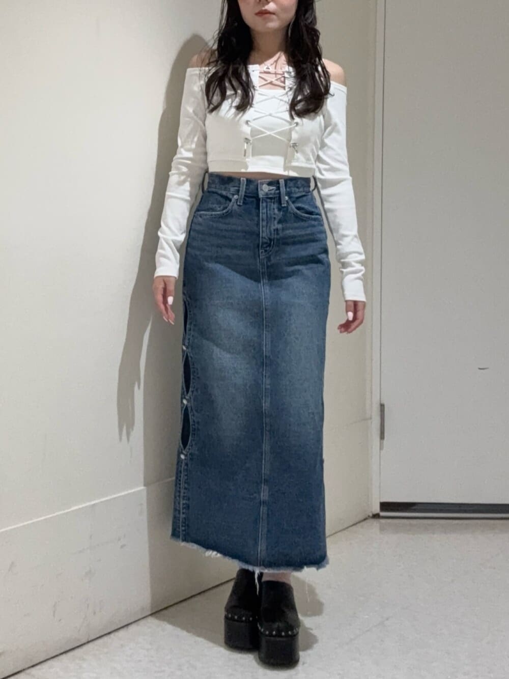 ホワイト系のTシャツ/カットソー、ブラック系のサンダル、ブルー系のデニムスカートを着用したレディースの春コーディネートの1枚目の写真