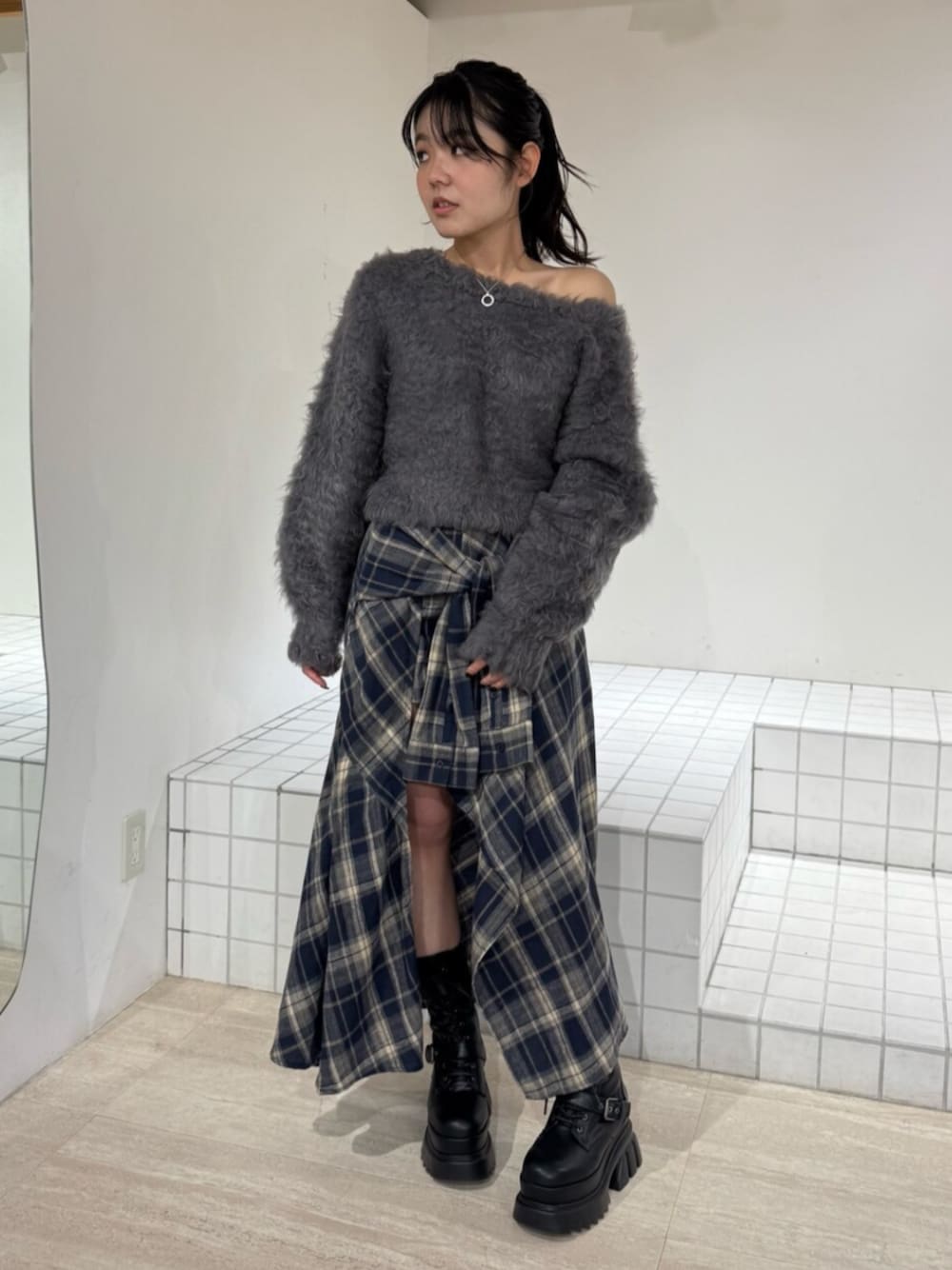 ブルー系のスカート、ブラック系のブーツ、グレー系のニット/セーターを着用したレディースの秋コーディネートの1枚目の写真