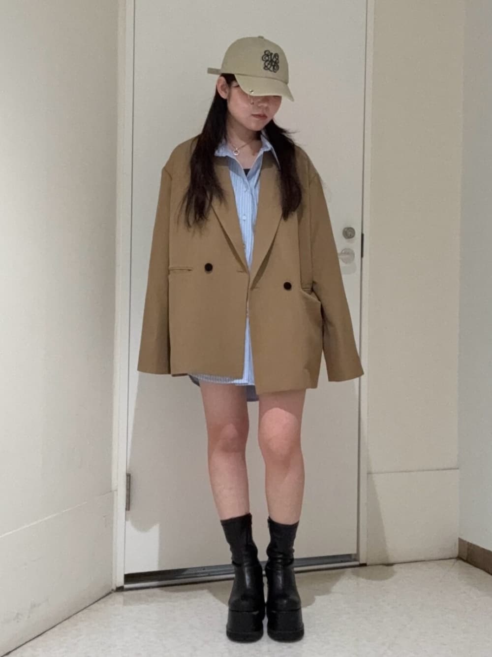 ブラック系のブーツ、ブラウン系のテーラードジャケット、ブルー系のシャツ/ブラウスを着用したレディースの春コーディネートの1枚目の写真