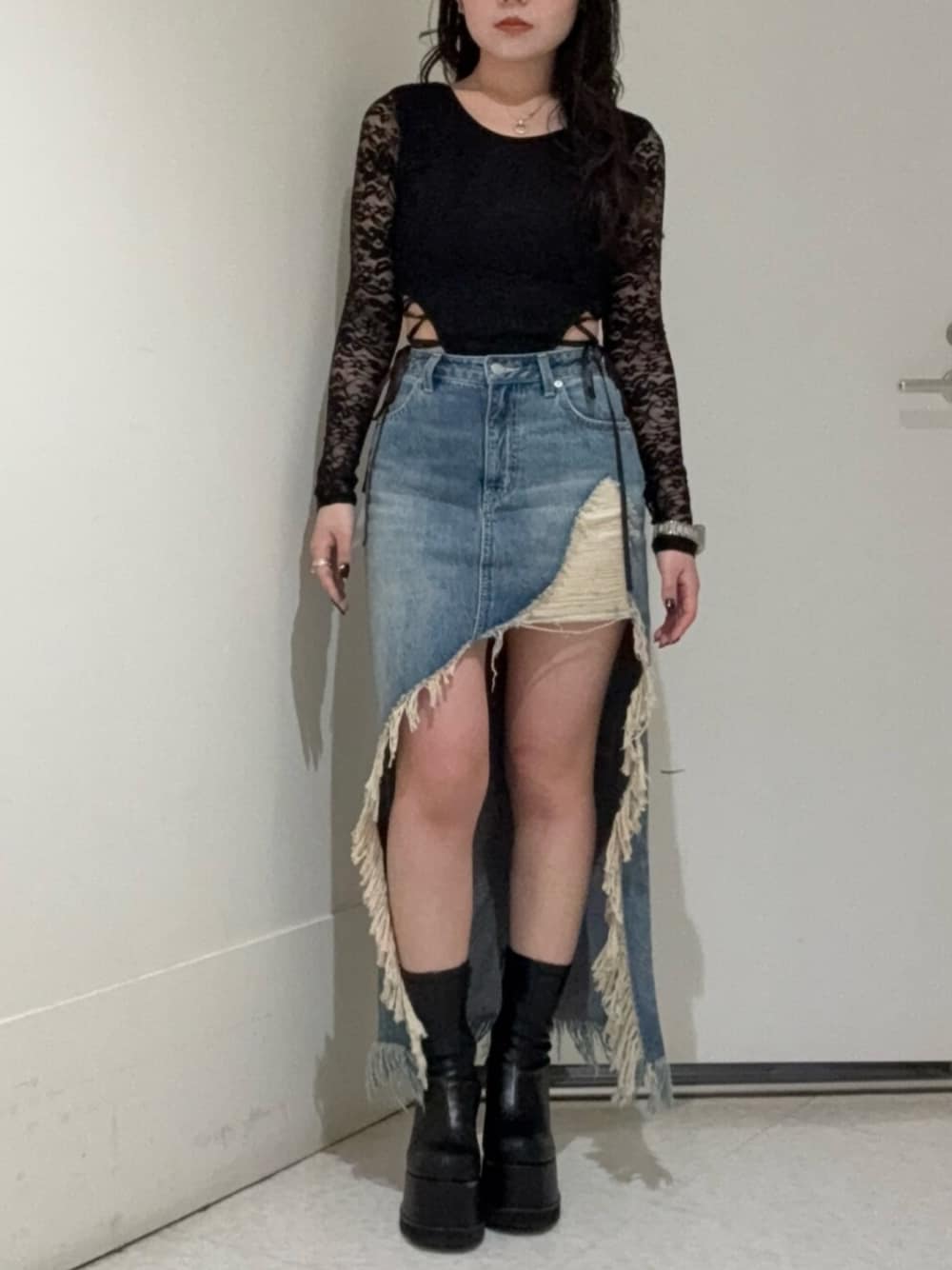 ブラック系のブーツ、ブルー系のデニムスカート、ブラック系のTシャツ/カットソーを着用したレディースの春コーディネートの1枚目の写真