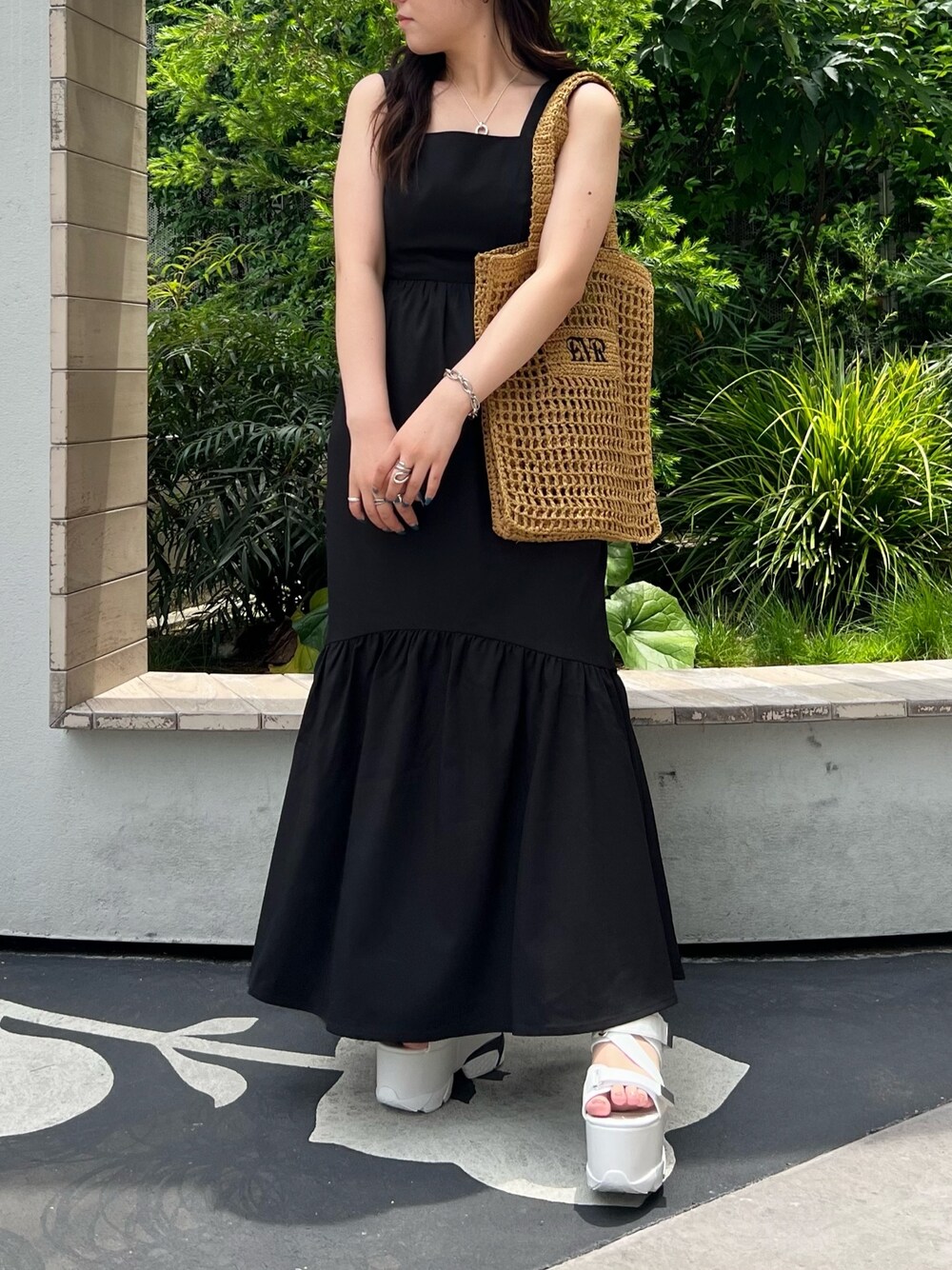 ブラック系のワンピース、ベージュ系のトートバッグ、ホワイト系のサンダルを着用したレディースの夏コーディネートの1枚目の写真