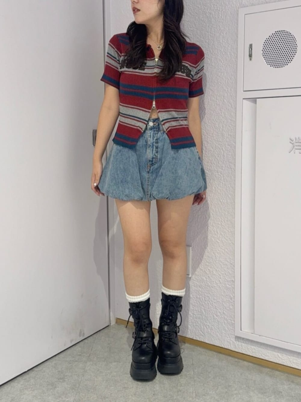 ブラック系のブーツ、ブルー系のデニムスカート、レッド系のニット/セーターを着用したレディースの夏コーディネートの1枚目の写真