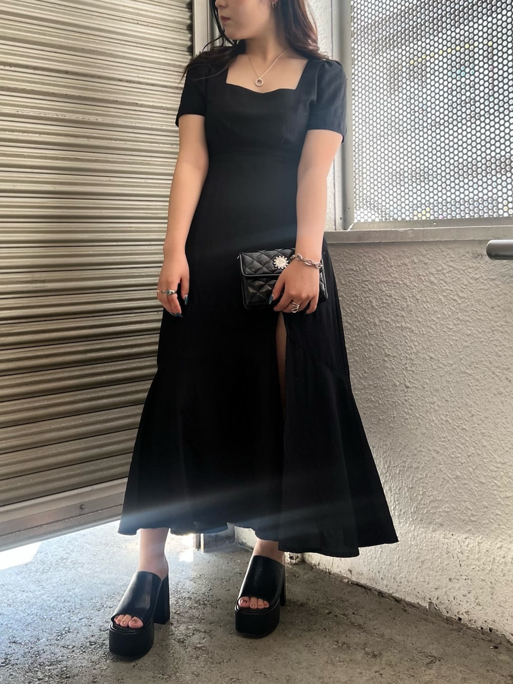 ブラック系のワンピース、ブラック系のショルダーバッグ、ブラック系のサンダルを着用したレディースの夏コーディネートの1枚目の写真