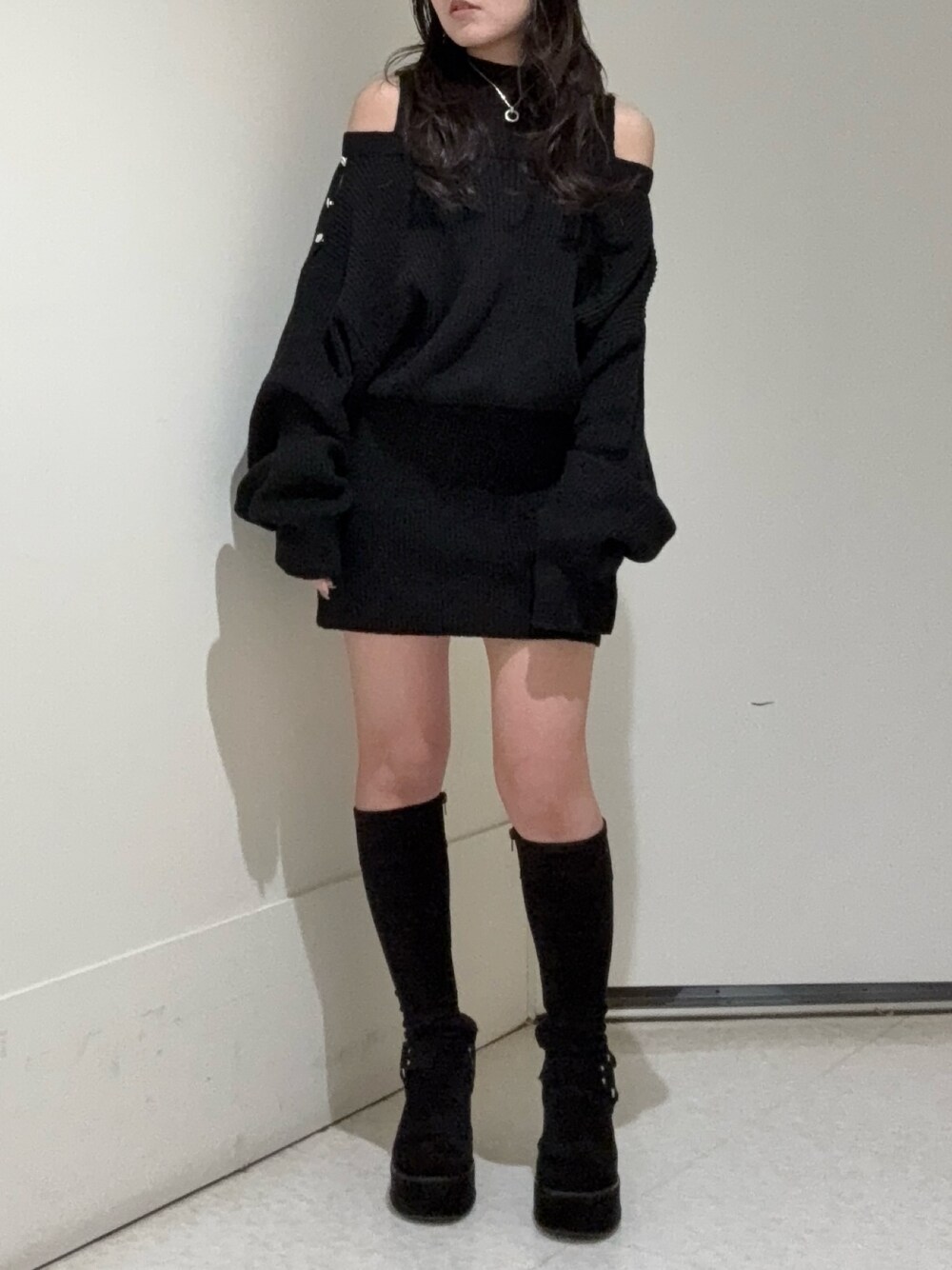 ブラック系のワンピース、ブラック系のブーツを着用したレディースの冬コーディネートの1枚目の写真