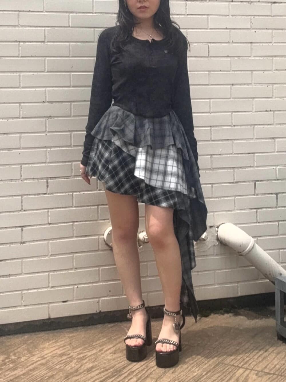 レッド系のTシャツ/カットソー、ブラック系のスカート、ブラック系のサンダルを着用したレディースの春コーディネートの1枚目の写真
