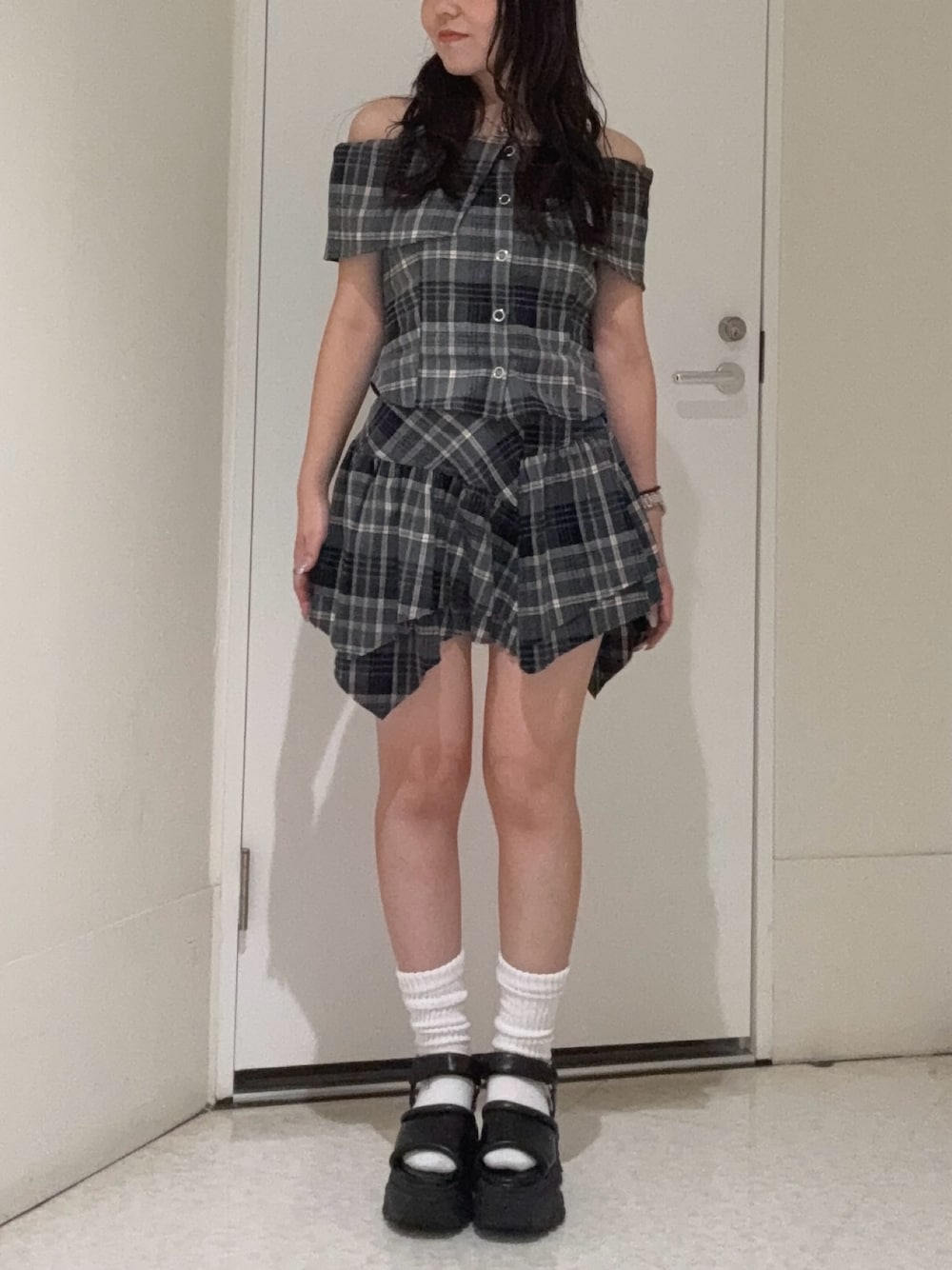 ブラック系のシャツ/ブラウス、ブラック系のスカート、ブラウン系のサンダルを着用したレディースの夏コーディネートの1枚目の写真