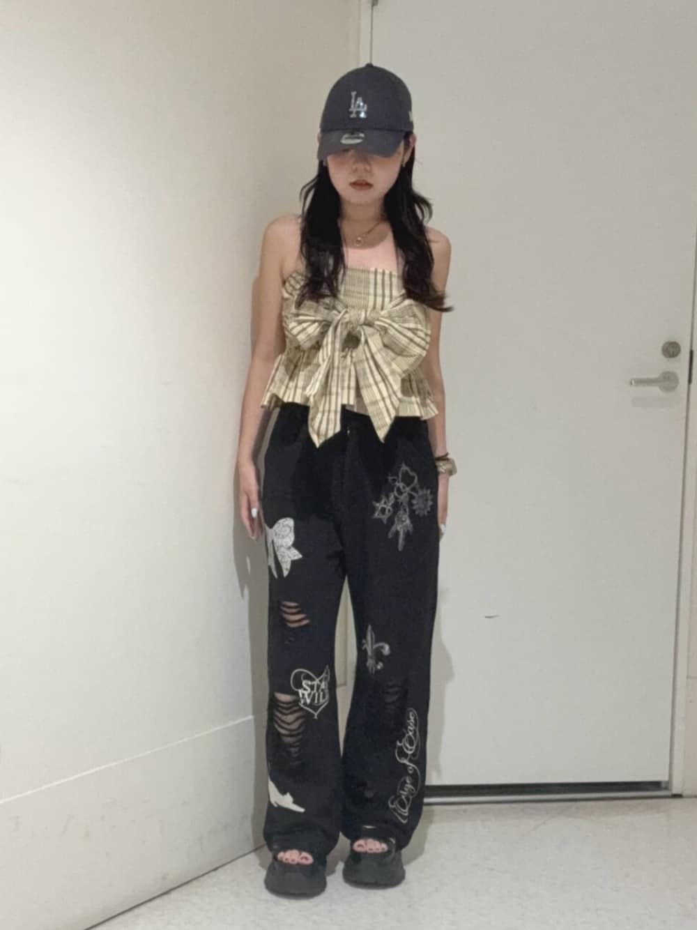 ブラック系のサンダル、ブラック系のスウェットパンツ、イエロー系のキャミソールを着用したレディースの夏コーディネートの1枚目の写真