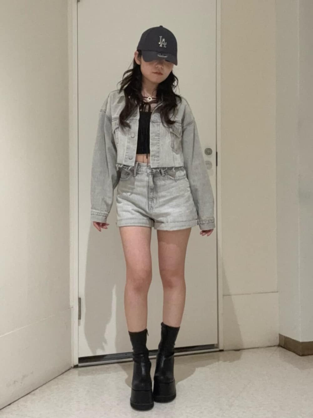 ブラック系のブーツ、グレー系のデニムパンツ、グレー系のデニムジャケットを着用したレディースの冬コーディネートの1枚目の写真