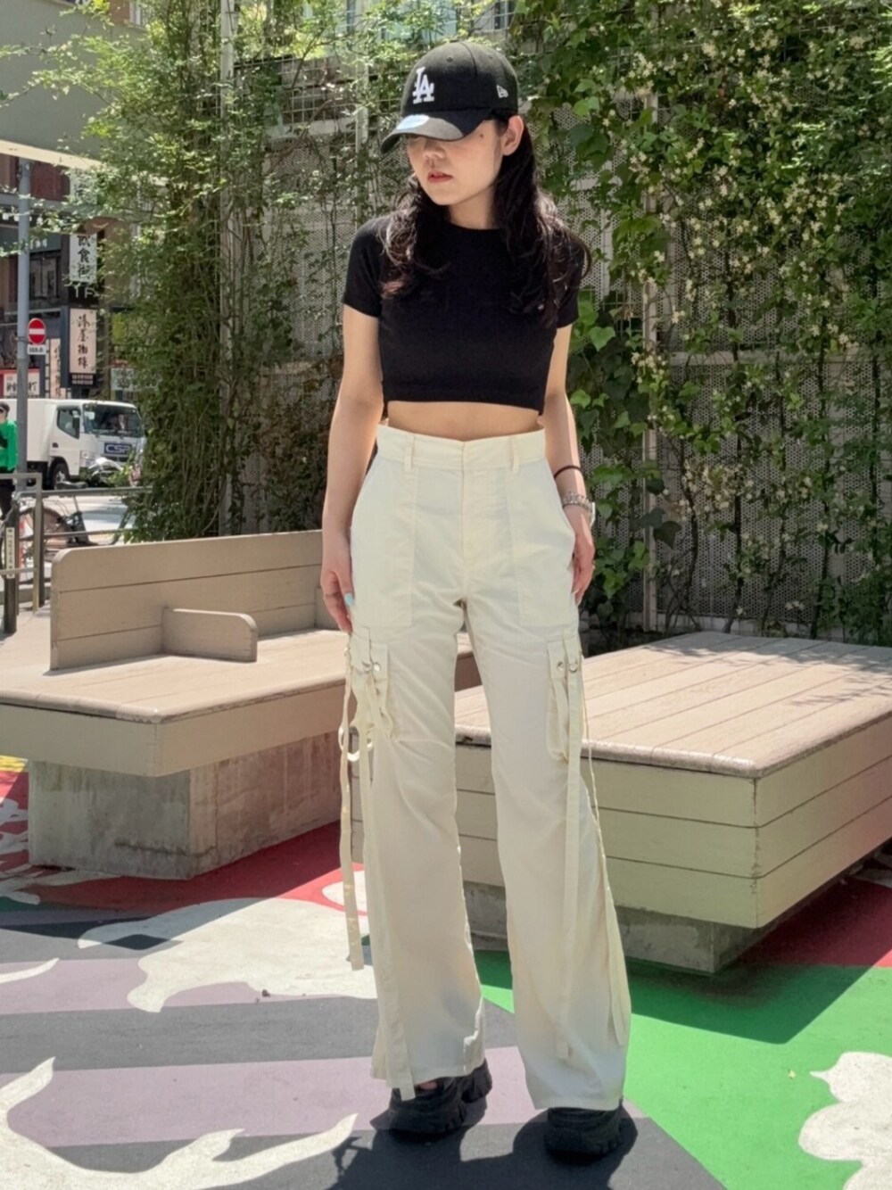 ブラウン系のサンダル、ブラック系のTシャツ/カットソー、ホワイト系のカーゴパンツを着用したレディースの春コーディネートの1枚目の写真