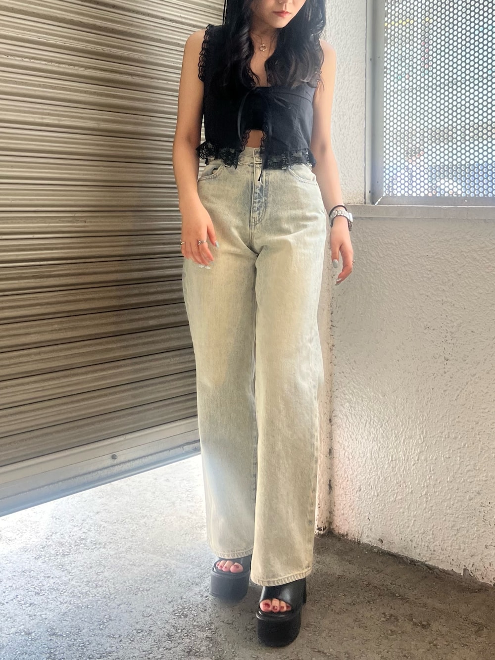 ブルー系のデニムパンツ、ブラック系のサンダルを着用したレディースの夏コーディネートの1枚目の写真
