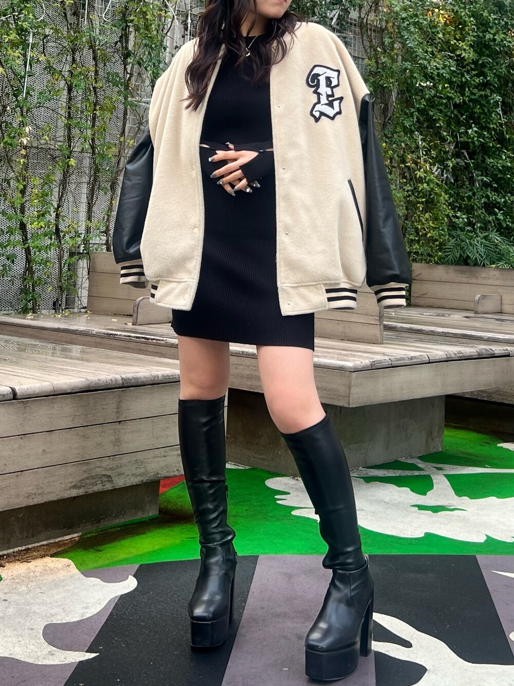 ブラック系のワンピース、ベージュ系のスタジャン、ブラック系のブーツを着用したレディースの冬コーディネートの1枚目の写真