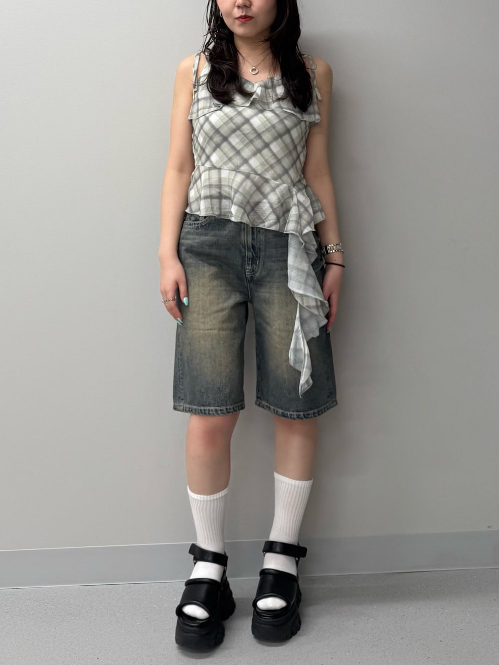ブルー系のデニムパンツ、イエロー系のキャミソール、ブラウン系のサンダルを着用したレディースの春コーディネートの1枚目の写真