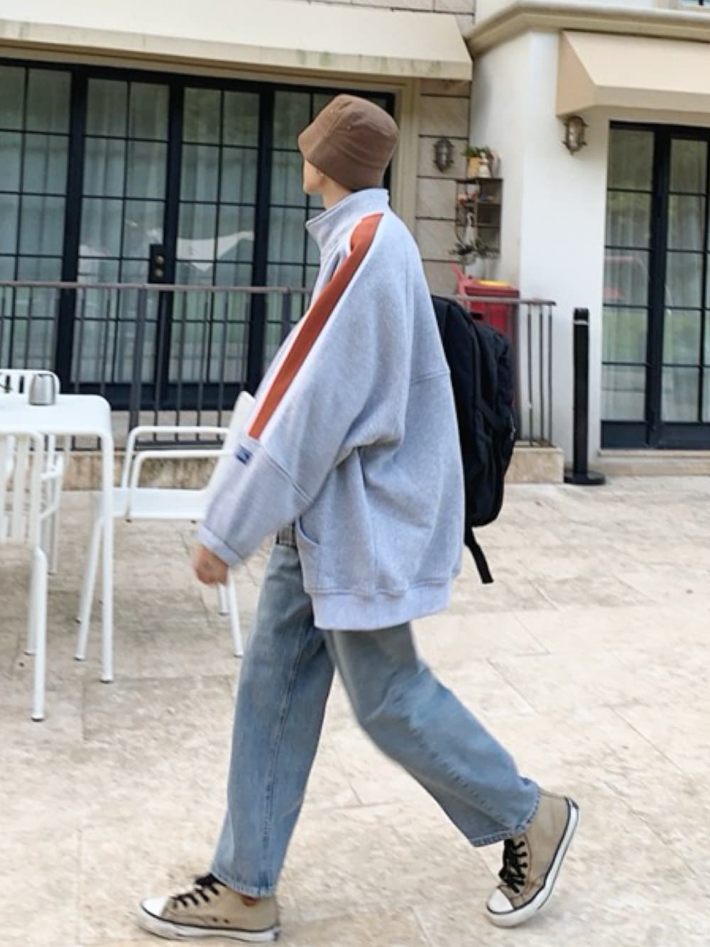 グレー系のスウェット、ブルー系のデニムパンツ、ベージュ系のスニーカーを着用したメンズの春コーディネートの1枚目の写真