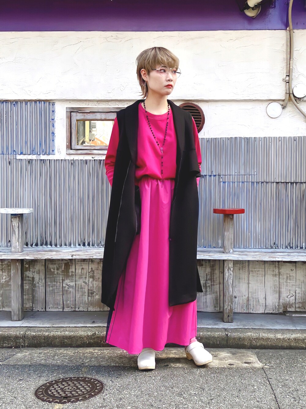 パープル系のスウェット、ピンク系のスカート、ブラック系のその他アウターを着用したレディースの秋コーディネートの1枚目の写真