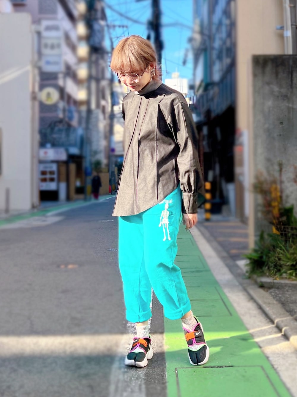 ブラック系のシャツ/ブラウス、ブルー系のパンツ、ブラック系のスニーカーを着用したレディースの冬コーディネートの1枚目の写真